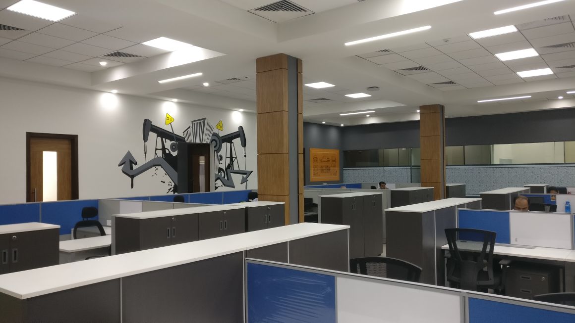 Open-plan Minda office showing branded mural wall, timber columns and blue workstation clusters